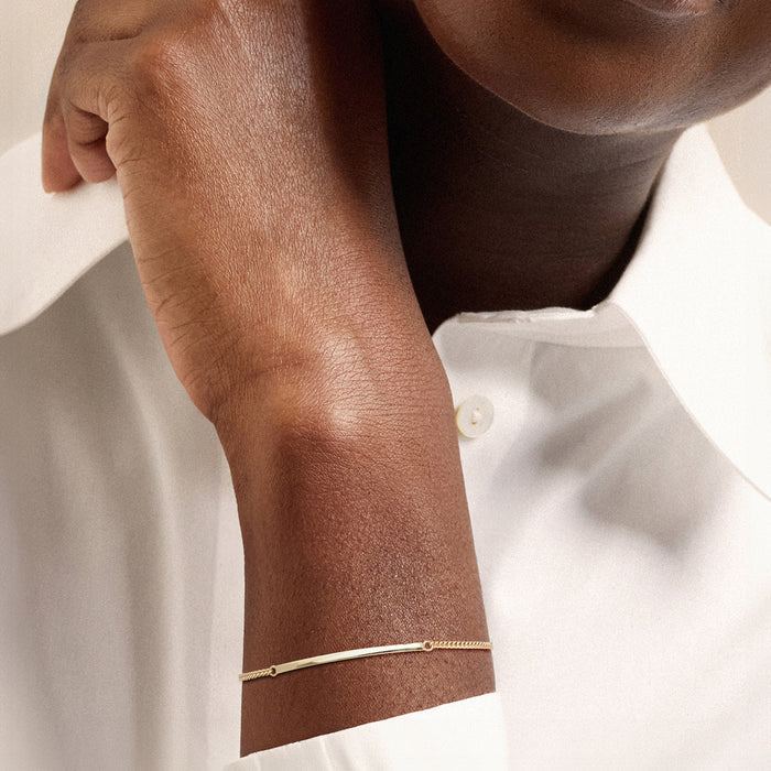 10kt yellow gold bar bracelet with curb links and thin round-ring clasp on wrist