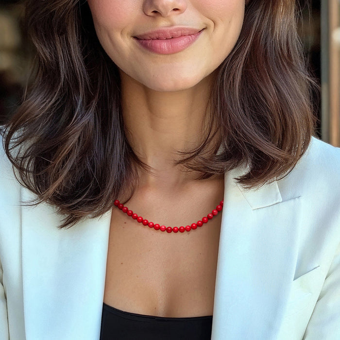 Red coral bead necklace worn at the collar with gold-toned finish