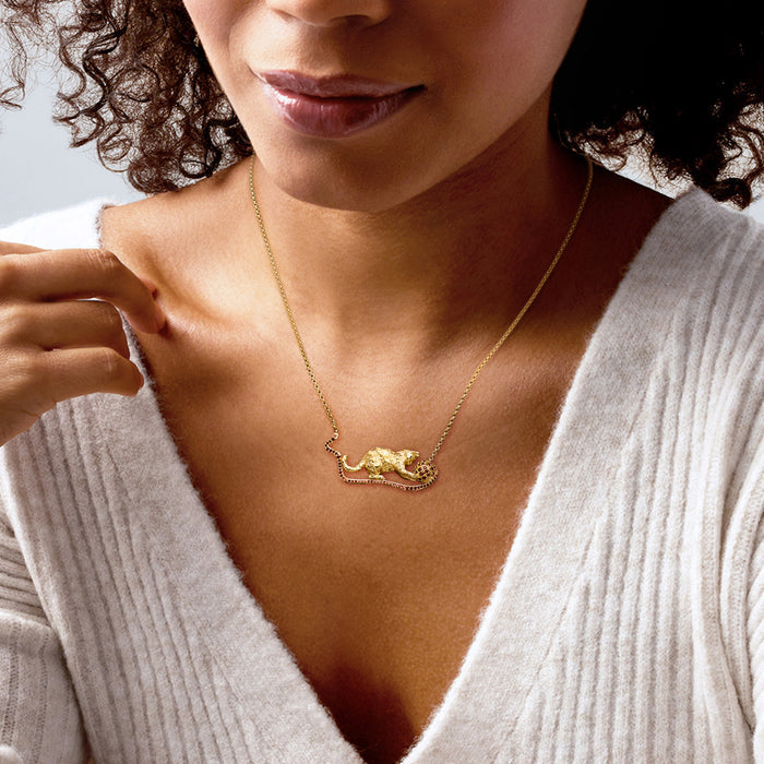 Cat pendant necklace in gold tone with red garnet yarn ball, worn at collar