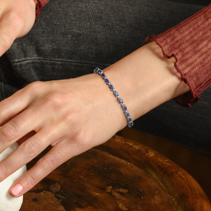 Sterling silver sapphire bracelet on wrist with blue stones and diamond highlights