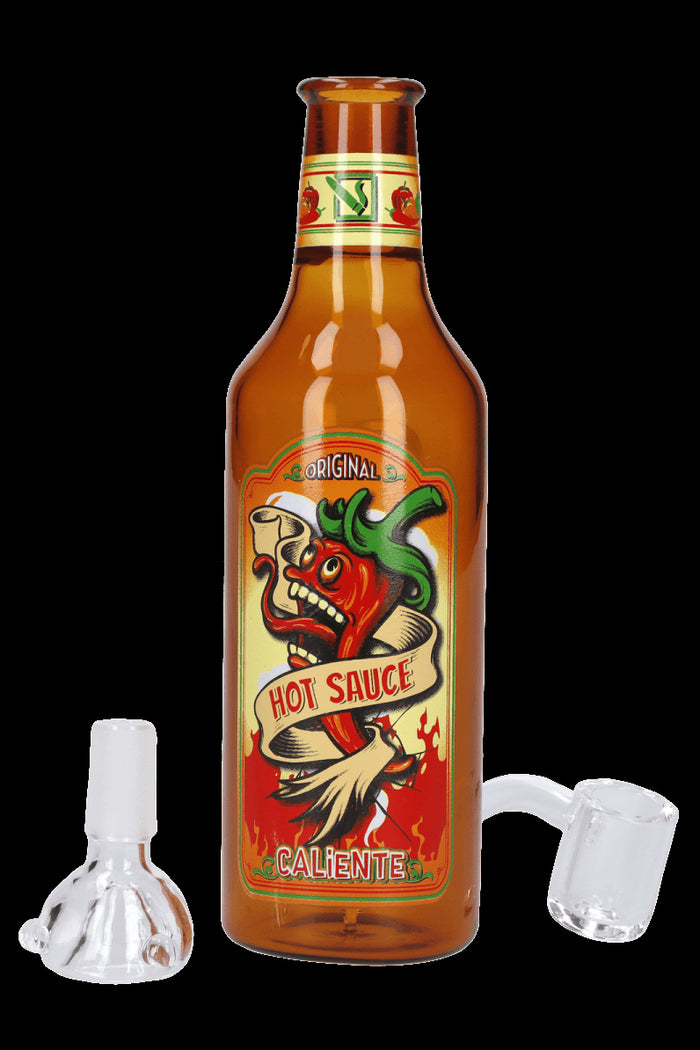 Hot sauce bottle with cannabis oil rigs displayed beside it.