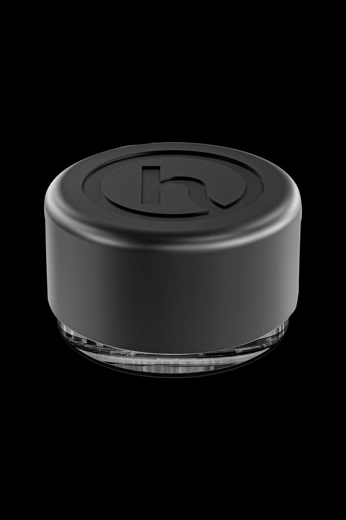 Black silicone cannabis concentrate container with clear base.