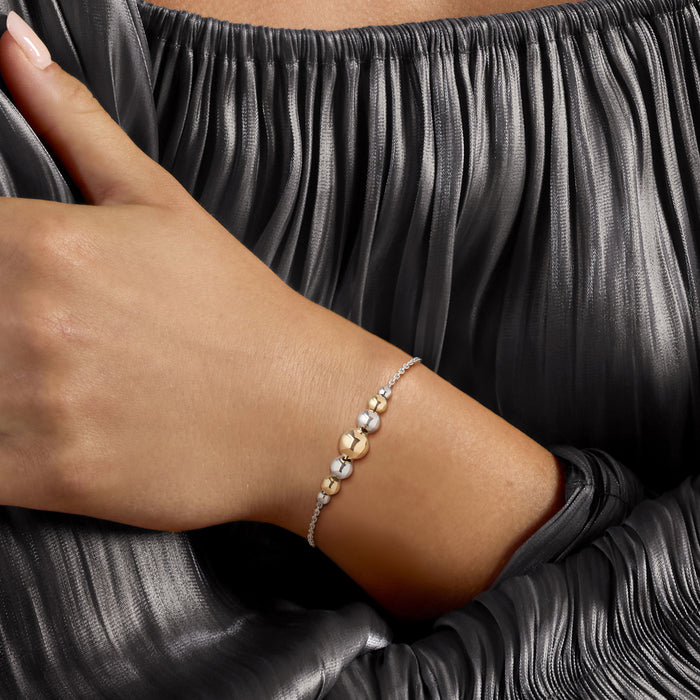 Gold and silver bead bolo bracelet on wrist with sterling silver adjustable clasp