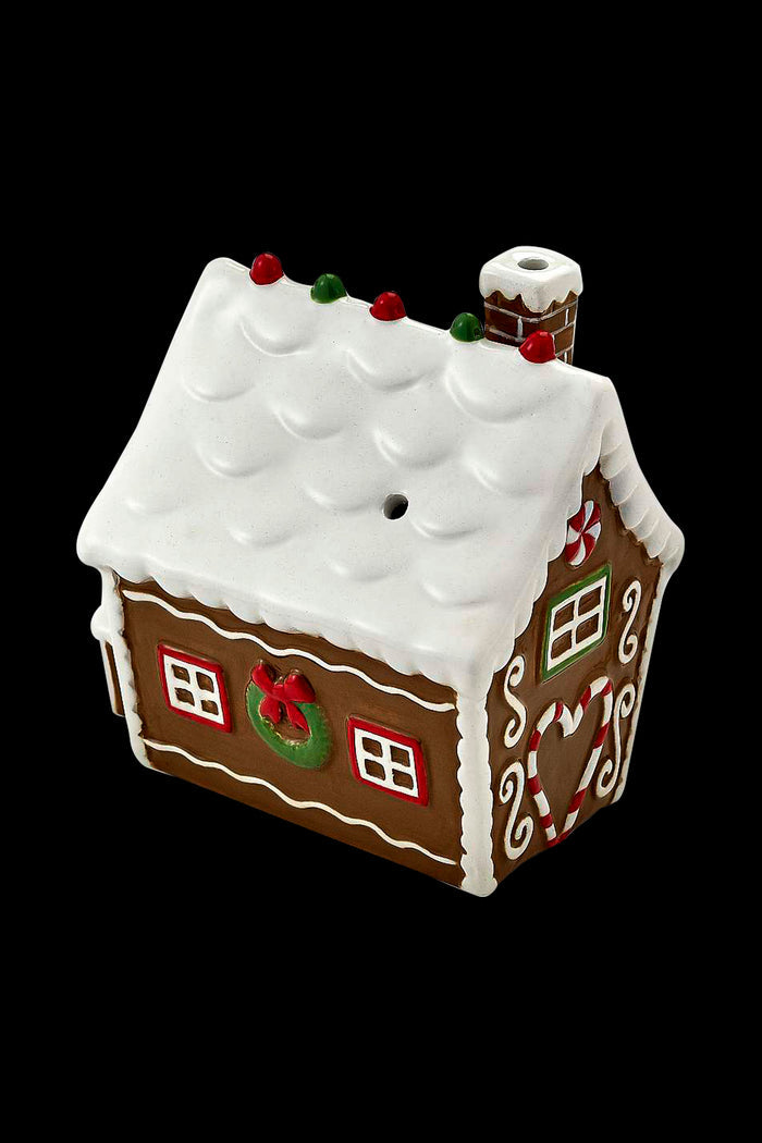 Gingerbread house-shaped cannabis pipe with white icing details and a chimney.