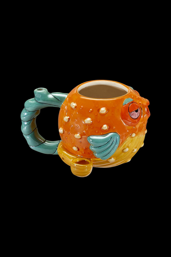Orange pufferfish-shaped ceramic water pipe with a teal handle and mouthpiece, isolated on a black background.