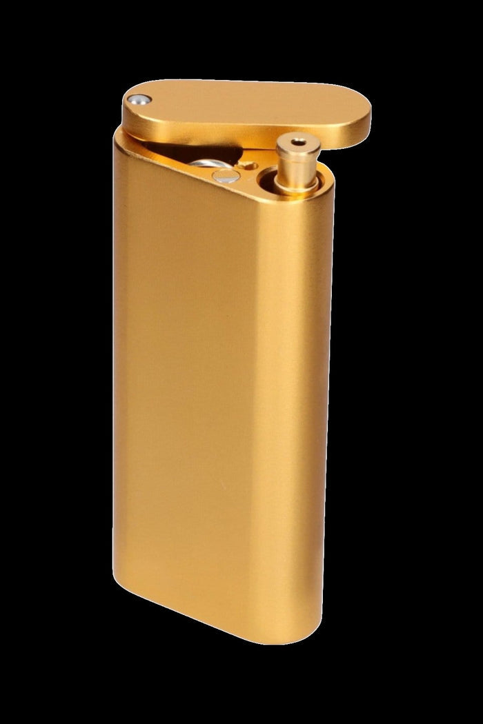 Close-up three-quarter view of a metallic gold Smoke Cartel Aluminum Dugout And Chillum with its flip lid open against a black background