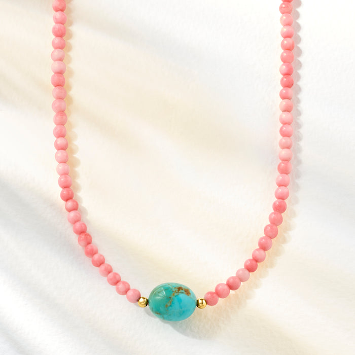 Pink coral bead necklace with turquoise oval center and small gold beads at sides